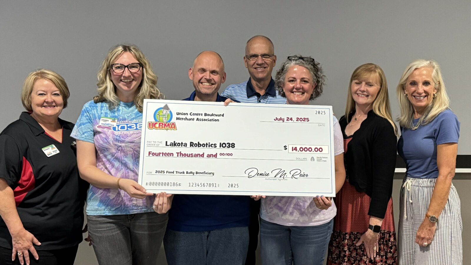 UCBMA presenting the 2025 Food Truck Rally check to Lakota Robotics